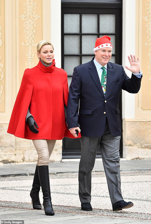 Princess Charlene and Prince Albert of Monaco, wearing festive hat and tie, in 2017