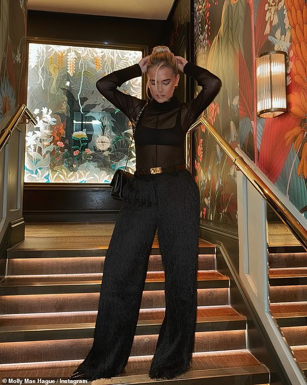 Despite her concerns, Molly-Mae looked nothing short of sensational in a stylish black mesh turtleneck and matching fringed trousers as she braved a storm in a beautiful location.