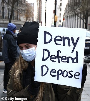 A supporter holds a sign with the words Mangione is said to have been left by the body of Brian Thompson