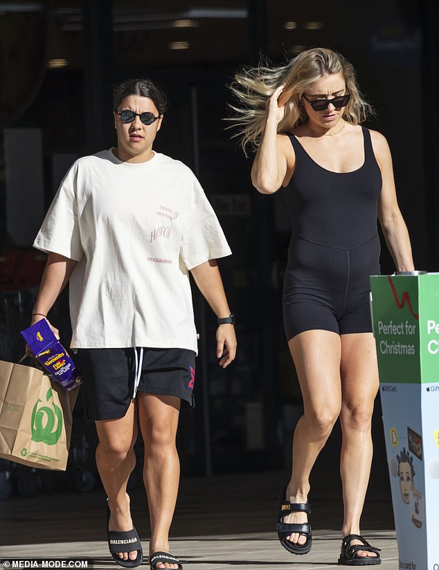 The Chelsea forward shielded her eyes with blue reflective shades and carried a shopping bag in one hand as they picked up some Christmas essentials, including a box of chocolates