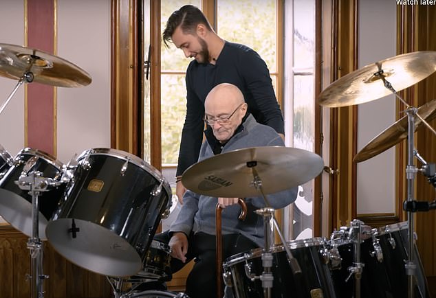 In a moving scene, the frail-looking musician emotionally returns to his personal drum kit, sitting at the instrument and holding a pair of sticks (pictured with his son Nic)