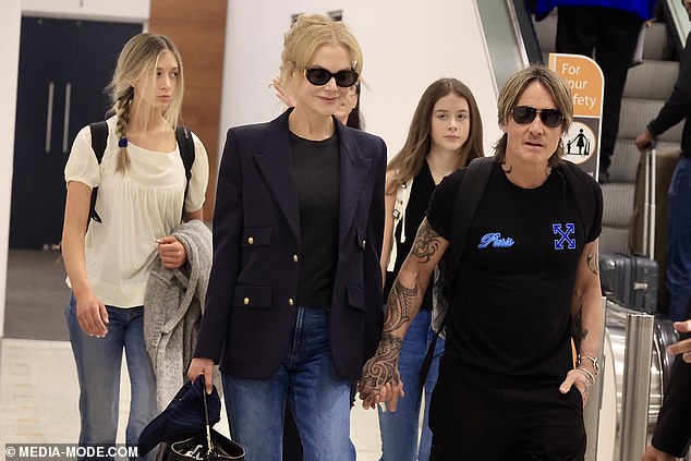 She put on a very affectionate show with musician Keith, 57, as the couple lovingly walked hand in hand through the arrivals hall after disembarking their Qantas flight.