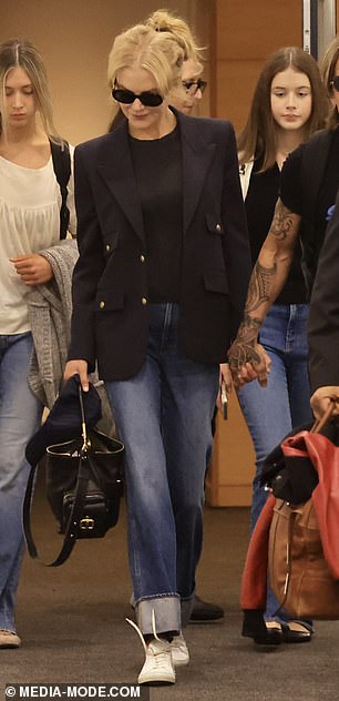 For her travels, she cut a stylish figure in a black T-shirt and straight-leg denim jeans