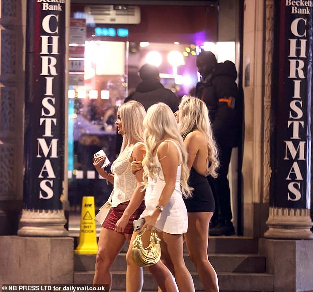 LEEDS: Three young women walk past the bright lights of a Leeds bar, clutching their handbags and phones