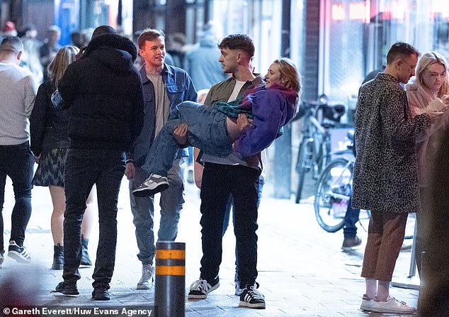 CARDIFF: A woman carries a woman down the middle of a busy street