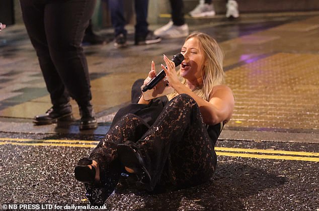 LEEDS: A reveler sits on the floor in a black lace outfit and holds a microphone as she prepares to serenade passers-by