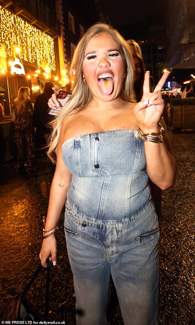 LEEDS: A clubber wearing a denim jumpsuit holds up a peace sign for the cameras