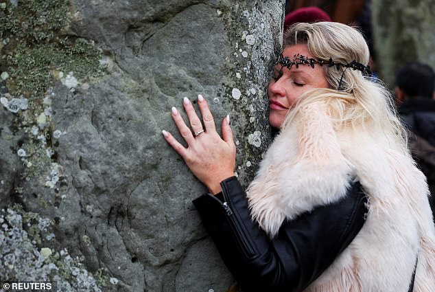 A reveler attends the winter solstice celebration at Stonehenge's stone circle today