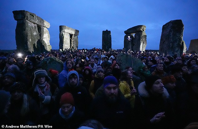 People take part in winter solstice celebrations during sunrise at the prehistoric monument Stonehenge on Salisbury Plain in Wiltshire