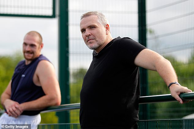 Peter (head, right) looks on during a media session for Tyson at a school in Bolton in 2014