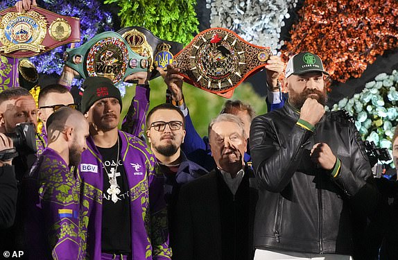 Boxers Tyson Fury of Great Britain, right, and world champion Oleksandr Usyk, center left, stand on stage during the weigh-in for their WBA, WBO and WBC heavyweight title fight in Riyadh, Saudi Arabia, Friday 20 December 2024. (AP photo/Frank Augstein)