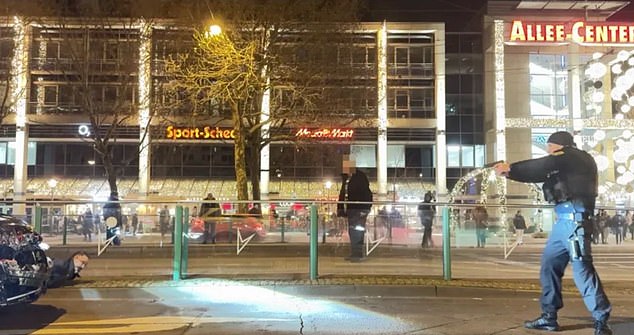 German police are seen pointing their guns at Abdulmohsen shortly before his arrest yesterday after he drove a car into a crowd of people at Magdeburg's Christmas market