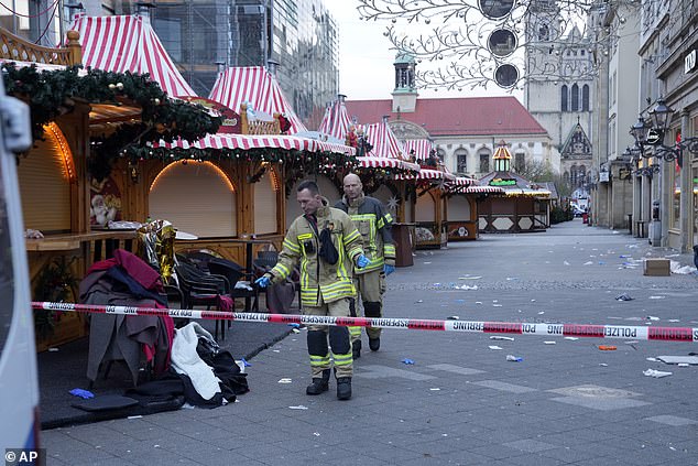 Firefighters work at a cordoned-off Christmas market, where a car plowed into a crowd in Magdeburg on Friday evening