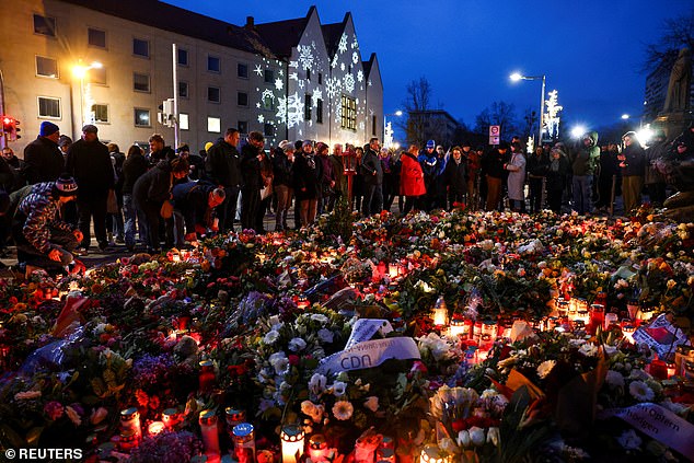 Mourners lit candles and placed flowers outside a church near the market