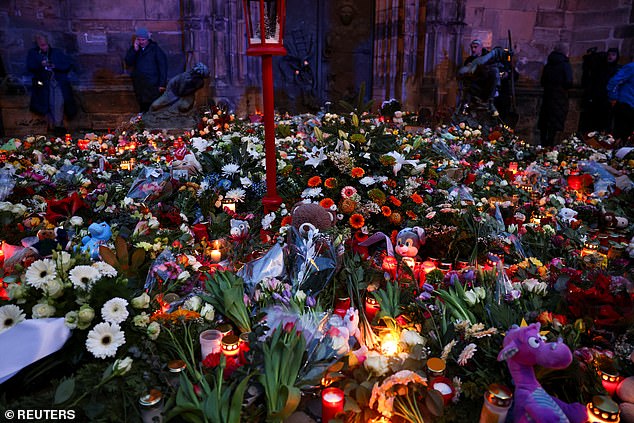 Stuffed animals, candles and floral tributes lie near the spot where a car plowed into a crowd at a Christmas market in Magdeburg