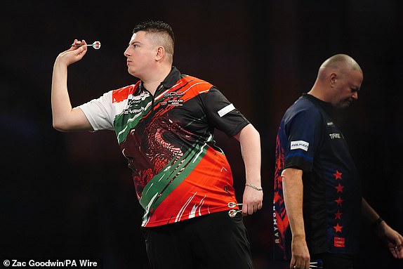 Nick Kenny in action during his second round match against Raymond van Barneveld (right) on day seven of the Paddy Power World Darts Championship at Alexandra Palace, London. Date of photo: Saturday, December 21, 2024. PA Photo. See PA story DARTS World. Photo credit should read: Zac Goodwin/PA Wire. RESTRICTIONS: Use subject to restrictions. Editorial use only, no commercial use without prior permission from the rights holder.