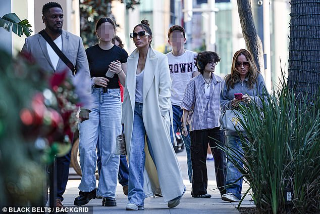 Flanked by her beaming crew, including her child Emme, JLo glided through the chic shopping area, clearly in good spirits as they smiled and laughed.