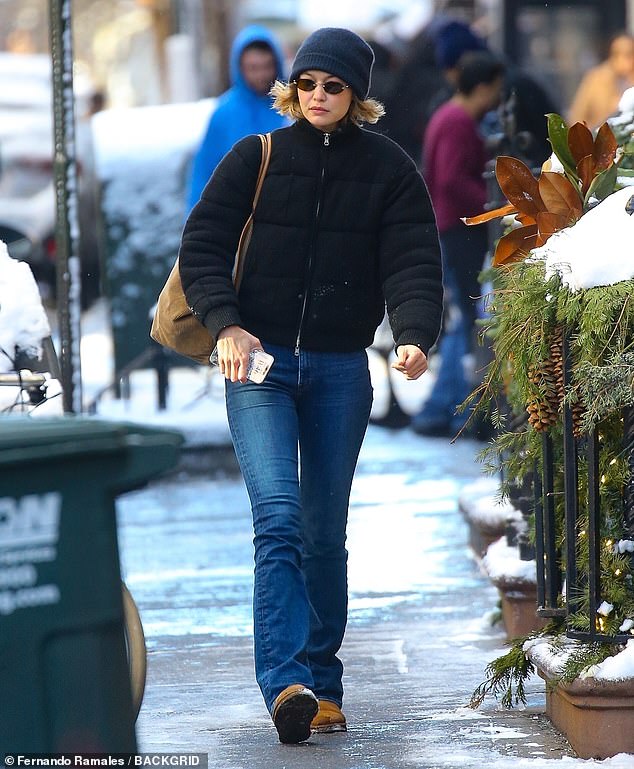 The 29-year-old model bundled up in a black puffer jacket and jeans paired with a beanie and brown winter boots