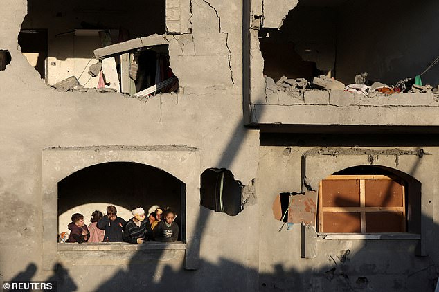 Palestinians inspect damage at the site of an Israeli attack on a house, amid the conflict between Israel and Hamas, in Deir Al-Balah, central Gaza Strip, December 22, 2024