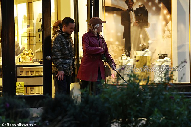 She added a pair of black high-heeled boots and a beige handbag, while hiding her famous face under a brown baseball cap