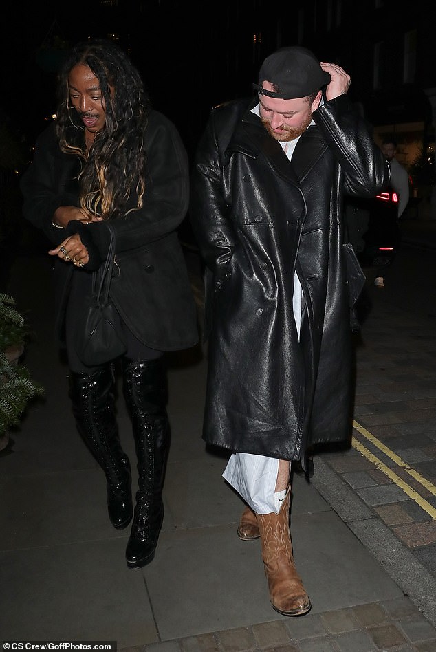 For the festive outing, Sam wore a pair of brown, distressed cowboy boots and wrapped up in a black leather trench coat