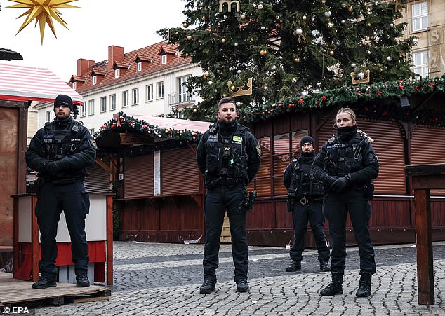 Police officers secure the area during the German Chancellor's visit to the site of a car ram attack at the Christmas market in Magdeburg