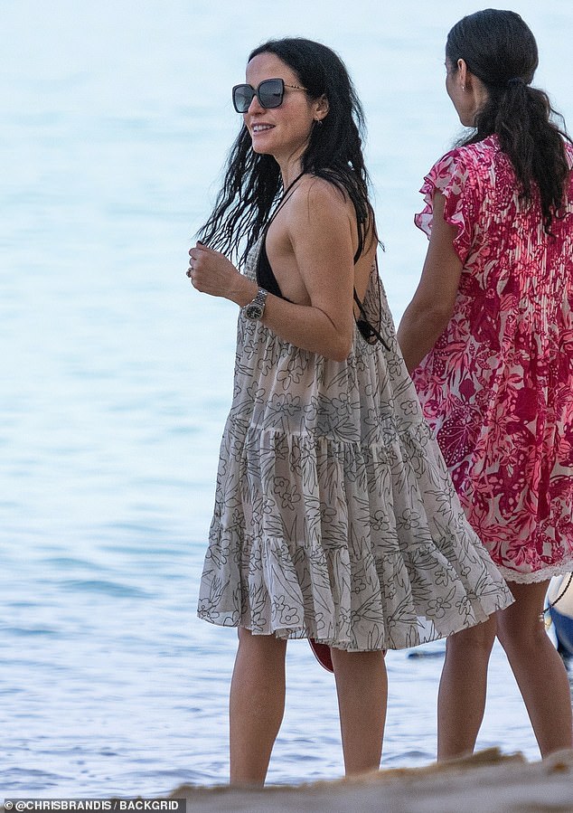 Andrea was seen throwing a white chiffon ruffled beach dress over her bikini