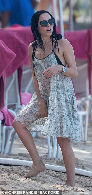 Her brunette locks were left in natural waves before sporting a wet look as she emerged from the sea