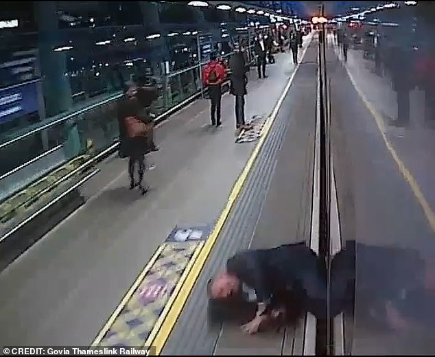 As the train pulls into the station, the man is knocked over by the carriage and nearly swept onto the tracks.