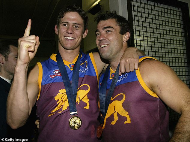 Shattock (left) is pictured with former teammate turned Geelong AFL coach Chris Scott after starring in the Lions' 2002 grand final victory