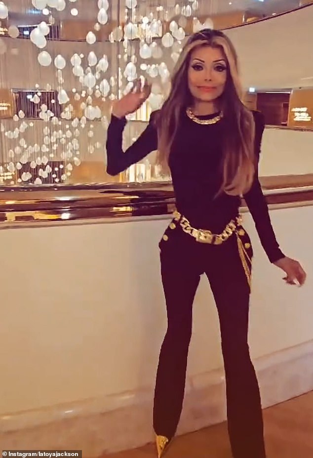 In the clip, La Toya donned a figure-hugging black jumpsuit and gold heels as she walked around her hotel and posed against the backdrop