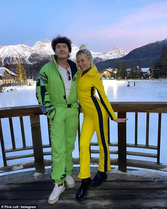 Pixie bundled up in black thermal pants underneath the swimsuit and stayed comfortable in a pair of chunky black boots as she posed with a friend who donned a green ski suit