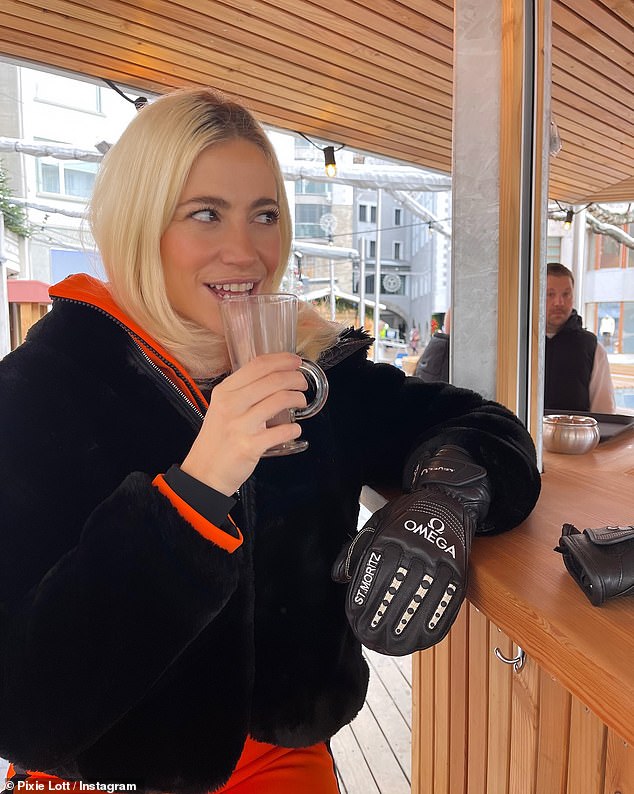 She looked incredible as she kept warm wearing a pair of Omega gloves as she sipped a cup of coffee at an outdoor bar