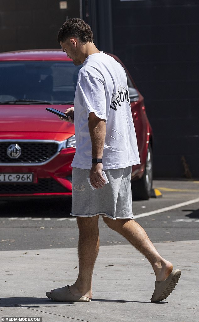 The 27-year-old added gray cut-off sweatpants and slide shoes in a matching color