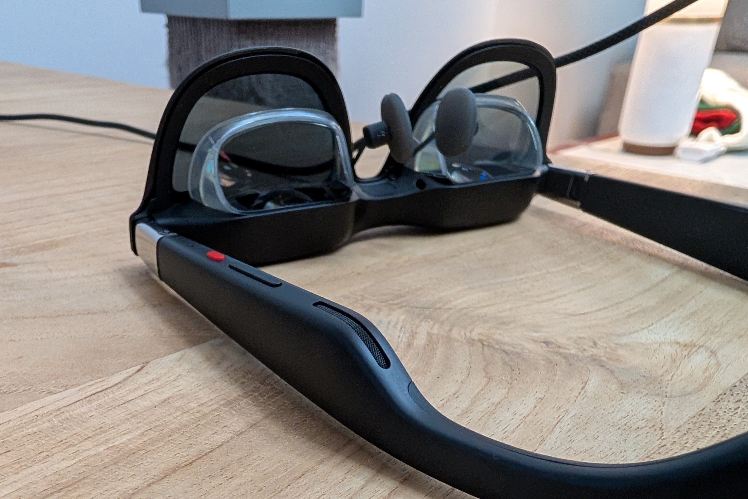 This image shows the Xreal One AR glasses turned upside down, exposing the speakers and buttons used to navigate the headset's controls.