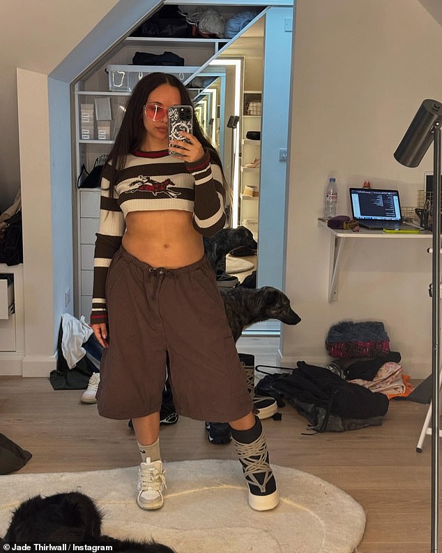 In the first of many mirror selfies, she opted for a cropped sweater and rose-colored glasses as she posed in baggy brown shorts.