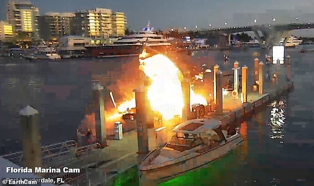 Pictured: Minutes later, the boat that exploded drifted off the dock, spreading the fire to another boat