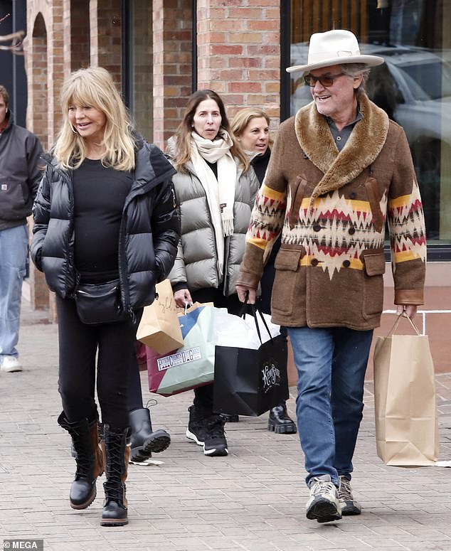 Kurt looked ready for winter wearing a brown double-breasted wool overcoat with furry shawl lapels, blue jeans and taupe hiking boots