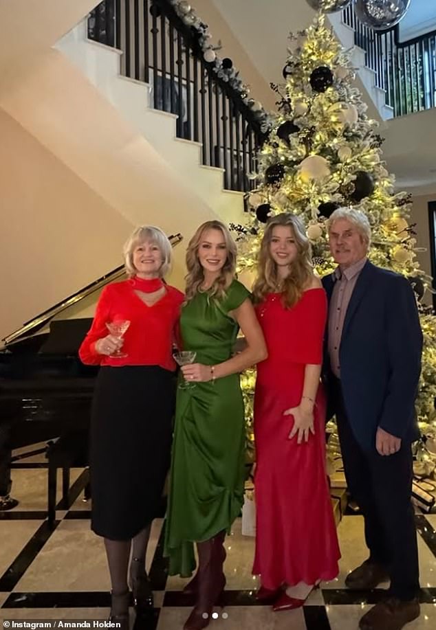 The radio host, 53, stunned in a satin green maxi dress paired with burgundy boots as she posed up a storm in front of her tree