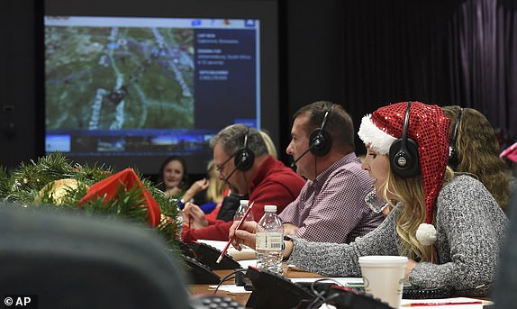 FILE - Santa Claus volunteer Meghan Huyck and other volunteers answer calls from children around the world at Peterson Air Force Base in Colorado Springs, Colorado, December 24, 2017. (Jerilee Bennett/The Gazette via AP, File)