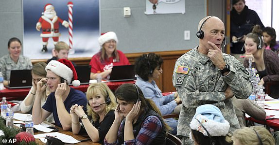 FILE - NORAD Chief of Staff Maj. Gen. Charles D. Luckey receives a call while volunteering at the NORAD Tracks Santa center at Peterson Air Force Base in Colorado Springs, Colorado, Dec. 24, 2014. (AP Photo/Brennan Linsley, File)