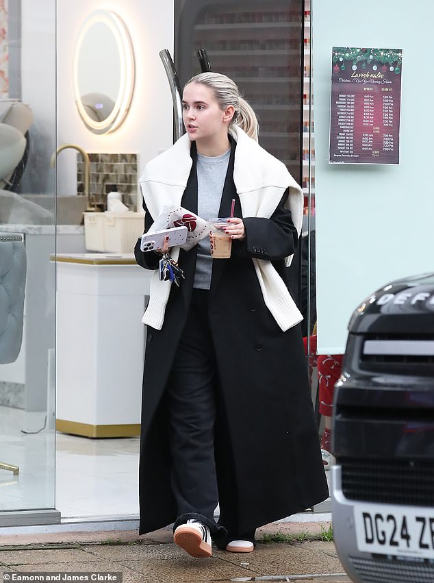 The former Love Island star, 25, looked cozy as she stepped out in a gray T-shirt, layered under a floor-length black trench coat