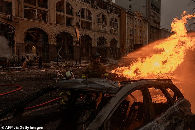 Ukrainian rescuers try to extinguish a fire at the site of a rocket attack in Kiev on December 20, 2024