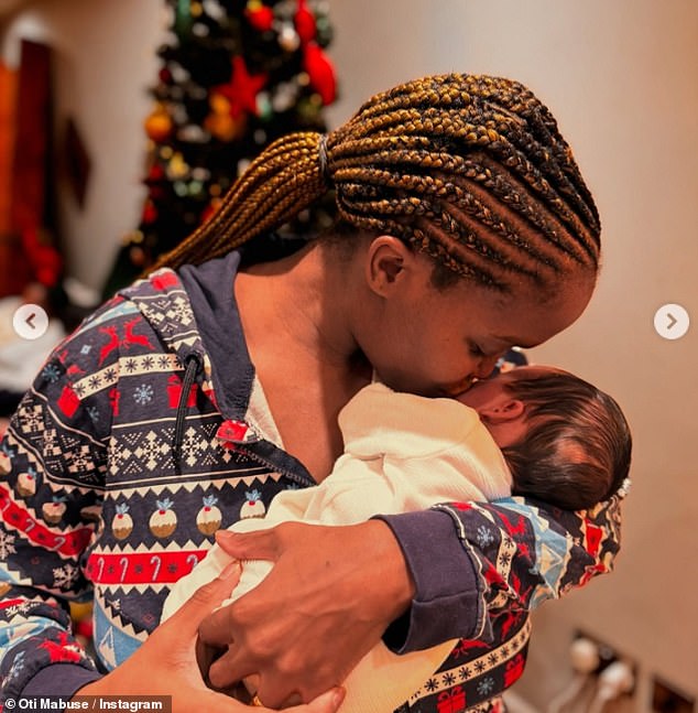 In another festive display, Oti cradled her daughter while dressed in a Christmas onesie