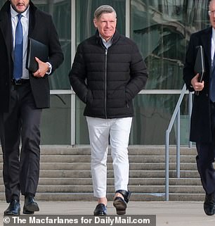 Matthew C. Smith (center) leaves his arraignment wearing an ankle monitor at Central Islip Federal Court in New York