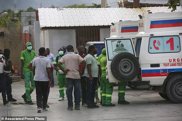 Medics inspect an ambulance carrying wounded people shot by armed gangs at the hospital