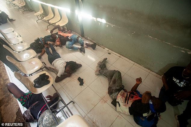 Injured people lie on the ground after gunmen opened fire on a group of journalists gathered for a government press conference to announce the reopening of Haiti's largest public hospital