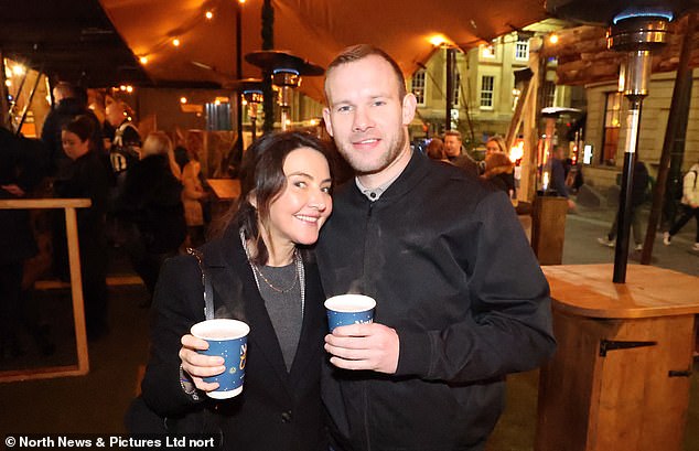 A man and a woman embrace in a bar in Newcastle as they prepare for Christmas Day