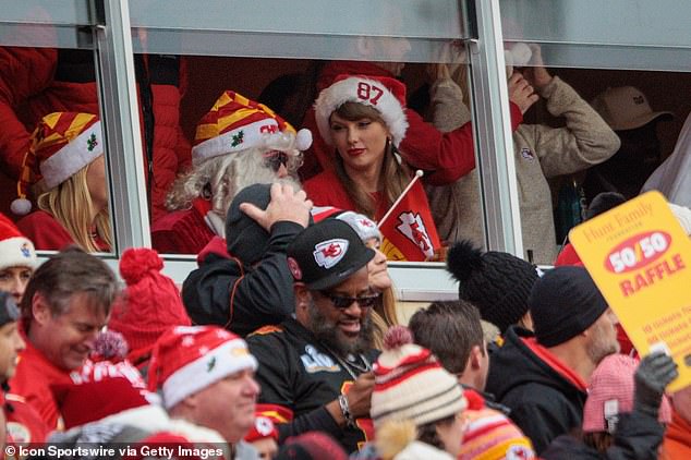 Taylor Swift talks to a Kansas City Chiefs fan dressed as Santa Claus at a 2023 game