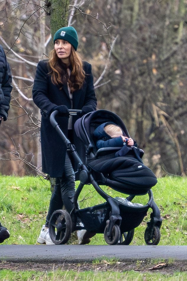 Gordon's wife Tana, 50, looked effortlessly stylish as she dressed warmly in a black trench coat and accessorized with a green beanie